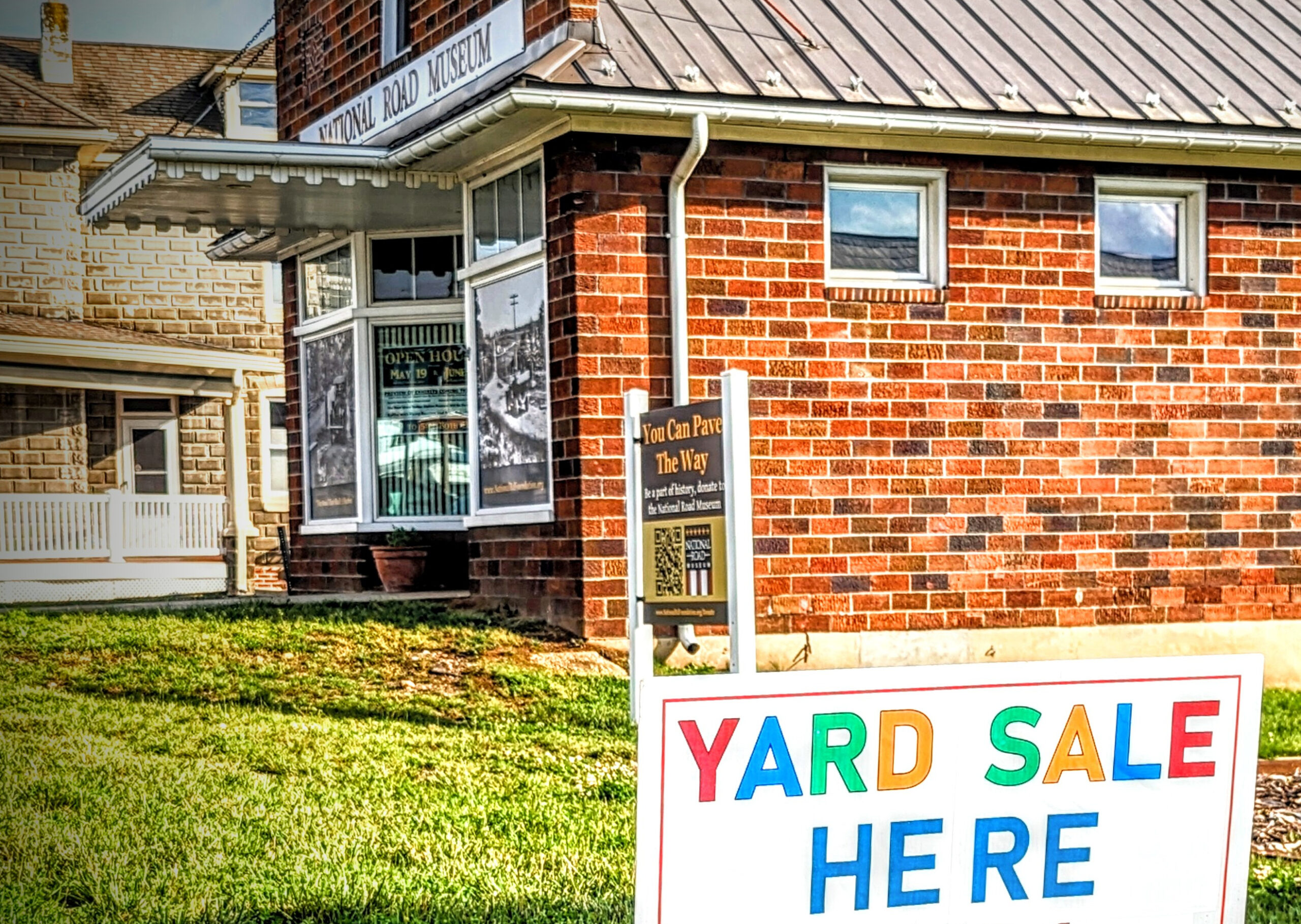 The front of the National Road Museum visible behind a sign reading 'Yard Sale Here"